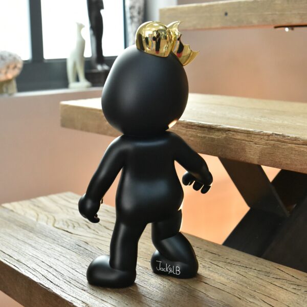 Jackelb figurine in black and gold on a stair