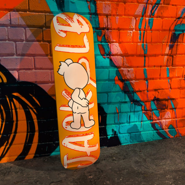 jack&lb orange skateboard against a street art wall