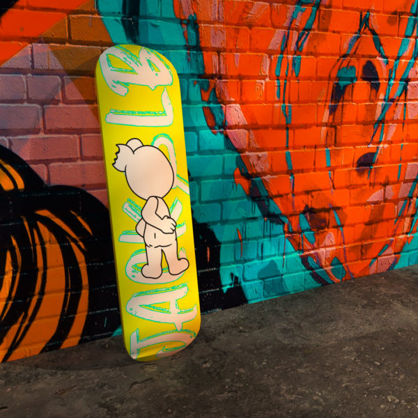 jack&lb yellow skateboard against a street art wall